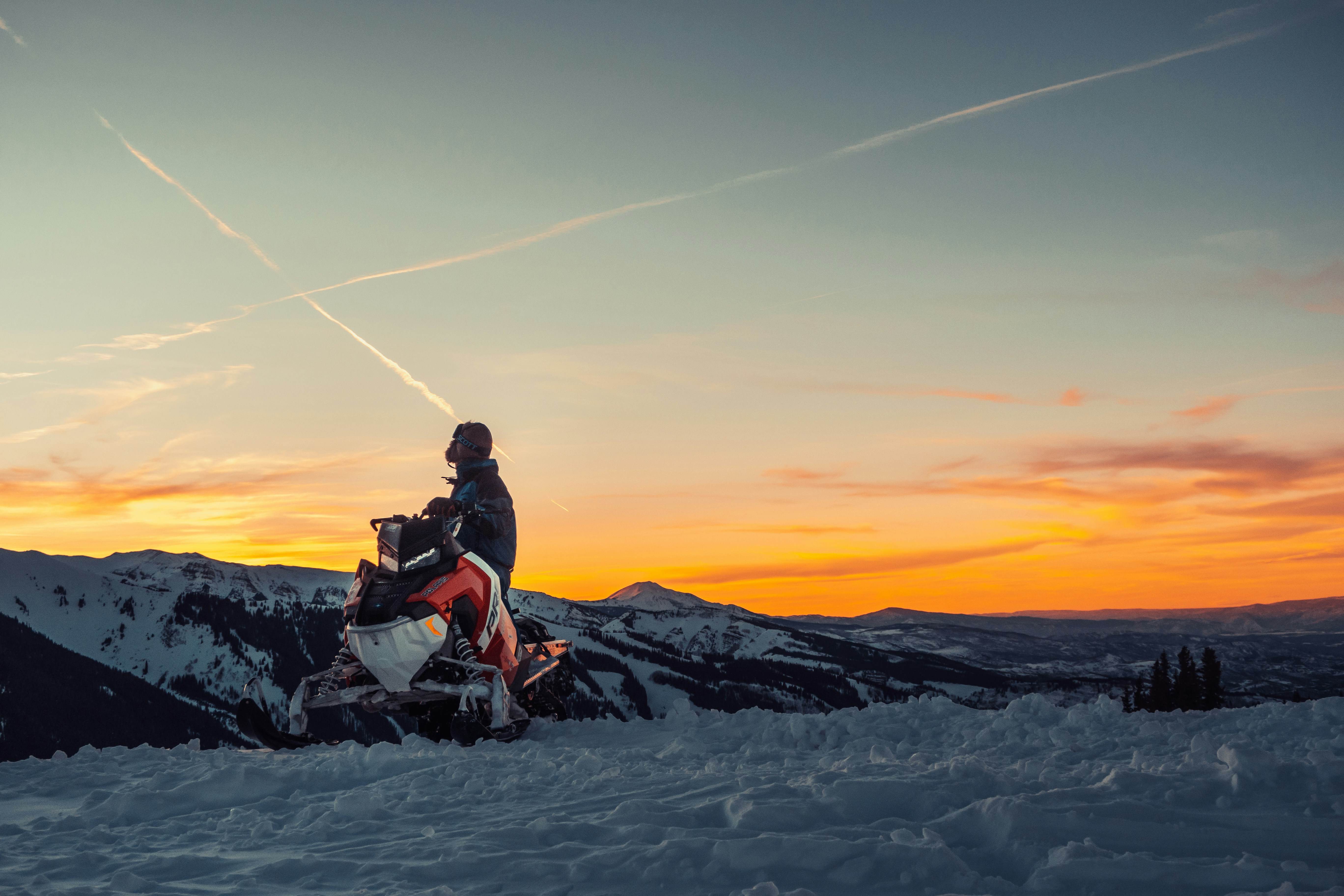Man enjoys riding a snowmobile in a snowy mountain